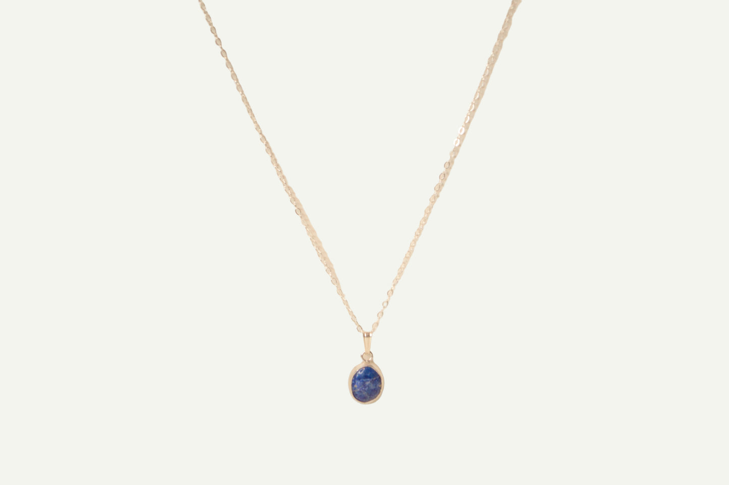 Necklace with a blue lapis pendant on a beige background