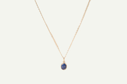 Necklace with a blue lapis pendant on a beige background