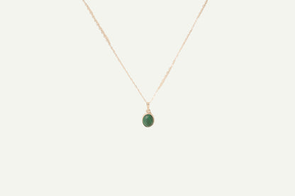 Necklace with a green malachite pendant on a beige background