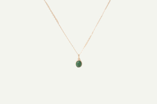 Necklace with a green malachite pendant on a beige background