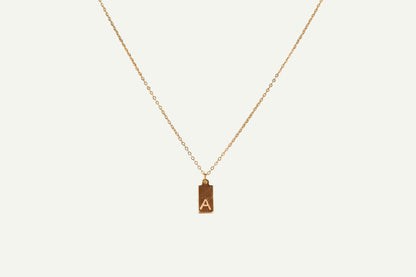 Gold necklace with a pendant featuring the letter 'A' on a white background