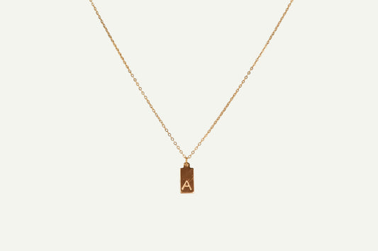 Gold necklace with a pendant featuring the letter 'A' on a white background